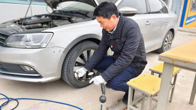汽車工程學(xué)院黨員教師為教職工車輛充氣